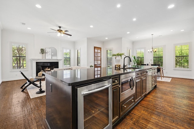 1120 Hemingway Ln, Irving, TX 75063 - kitchen with stainless steel microwave, wine cooler, a sink, a kitchen island with sink, and plenty of natural light