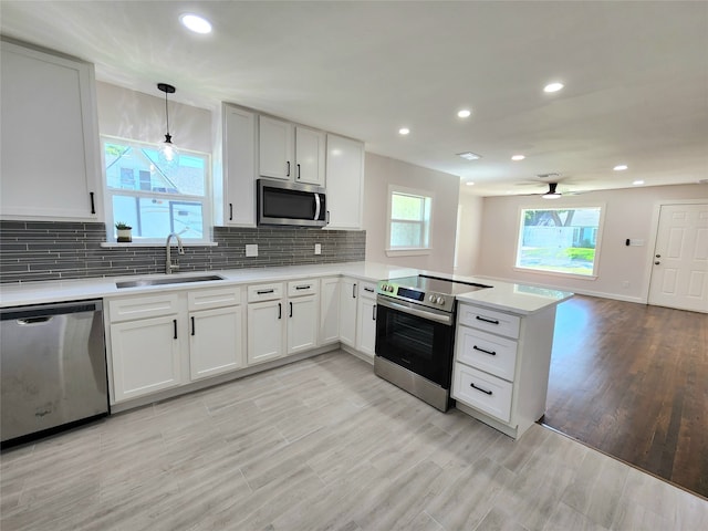 907 S Dixon St S, Gainesville, TX 76240 - kitchen with appliances with stainless steel finishes, a sink, a peninsula, light countertops, and backsplash
