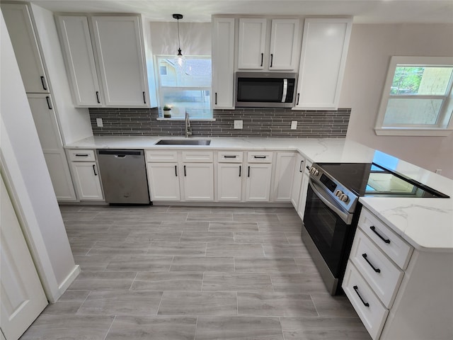 907 S Dixon St S, Gainesville, TX 76240 - kitchen featuring appliances with stainless steel finishes, a sink, backsplash, and white cabinetry