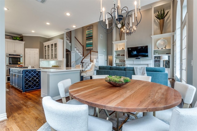 9352 Stratford Way, Dallas, TX 75220 - dining space featuring stairway, crown molding, wood finished floors, recessed lighting, and a chandelier