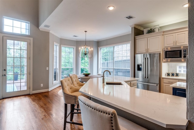 9352 Stratford Way, Dallas, TX 75220 - kitchen with stainless steel appliances, a sink, healthy amount of natural light, dark wood-style floors, and crown molding