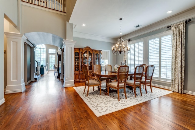 9352 Stratford Way, Dallas, TX 75220 - dining room featuring decorative columns, arched walkways, dark wood-style flooring, a chandelier, and baseboards