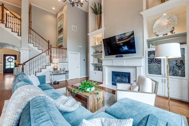 9352 Stratford Way, Dallas, TX 75220 - living area featuring a towering ceiling, stairs, wood finished floors, arched walkways, and ornamental molding