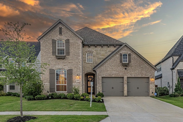 1050 Adair Rd, Prosper, TX 75078 - french country home featuring brick siding, a lawn, driveway, a shingled roof, and stone siding