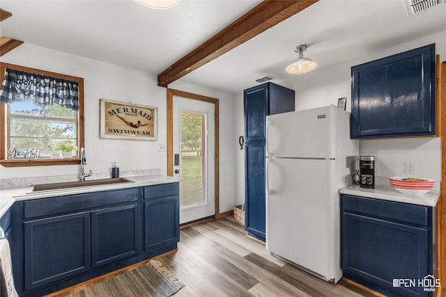 367 Penobscot Trl, Henrietta, TX 76365 - kitchen featuring freestanding refrigerator, blue cabinets, a sink, light wood finished floors, and beam ceiling