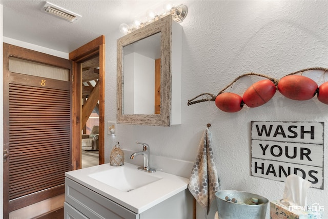 367 Penobscot Trl, Henrietta, TX 76365 - bathroom with a textured wall, vanity, and a textured ceiling