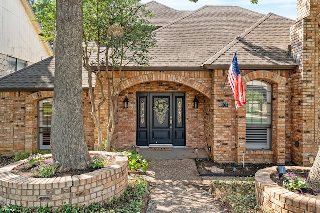 6607 Canalview Dr, Arlington, TX 76016 - doorway to property featuring brick siding, a shingled roof, and covered porch