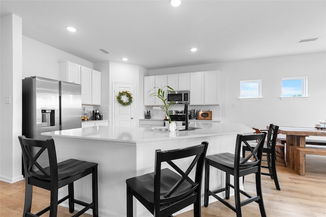 2939 Peony Dr, Sherman, TX 75092 - kitchen featuring appliances with stainless steel finishes, light countertops, white cabinets, a sink, and light wood-style flooring