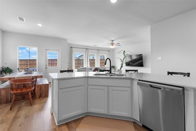 2939 Peony Dr, Sherman, TX 75092 - kitchen with stainless steel dishwasher, a sink, open floor plan, light countertops, and light wood-type flooring