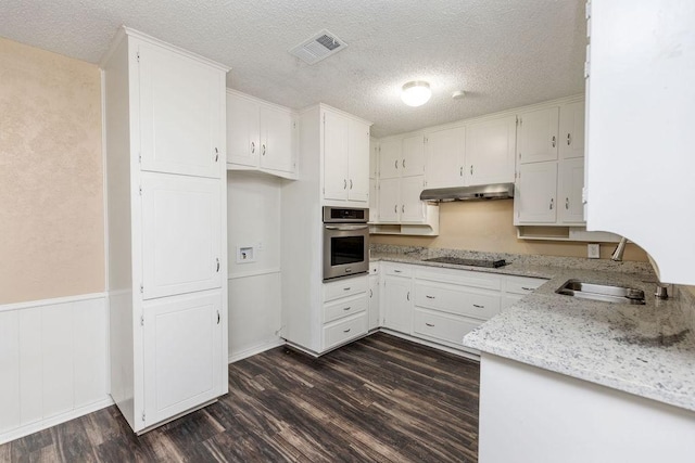 1425 Bryan Dr, Bedford, TX 76022 - kitchen featuring stainless steel oven, black electric stovetop, under cabinet range hood, a sink, and dark wood-style flooring