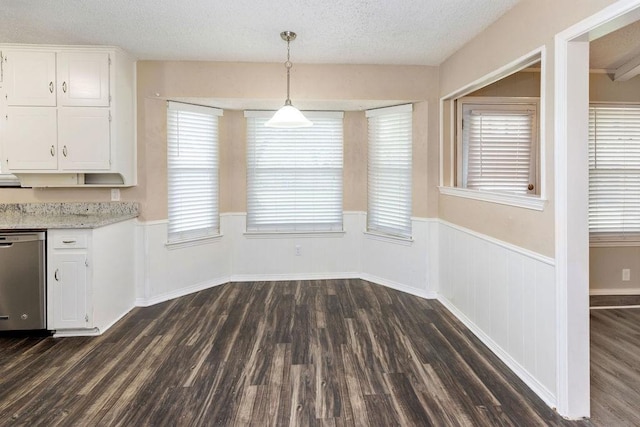 1425 Bryan Dr, Bedford, TX 76022 - unfurnished dining area with dark wood finished floors, wainscoting, and a textured ceiling