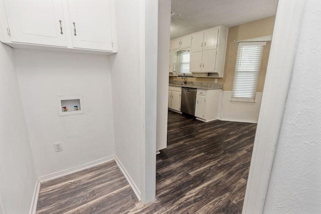 1425 Bryan Dr, Bedford, TX 76022 - laundry room featuring hookup for a washing machine, dark wood-style floors, cabinet space, a textured ceiling, and baseboards