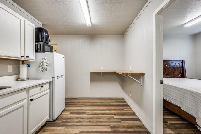 5205 Larue Dr, Caddo Mills, TX 75135 - kitchen with wood finished floors, white cabinetry, freestanding refrigerator, light countertops, and baseboards