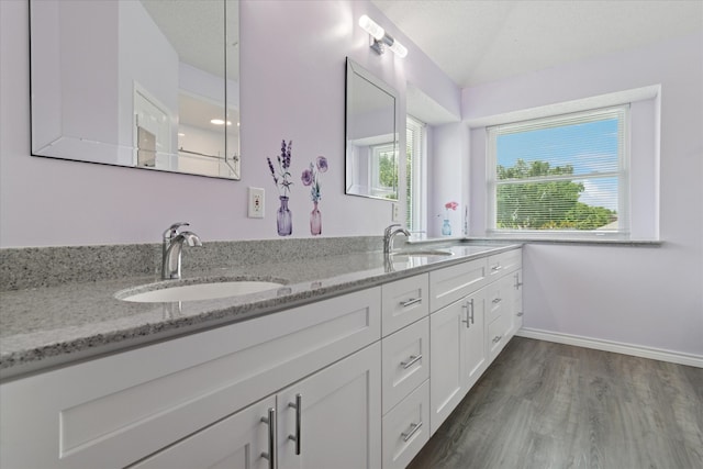 1302 Woodmont Dr, Allen, TX 75002 - bathroom featuring double vanity, wood finished floors, and baseboards