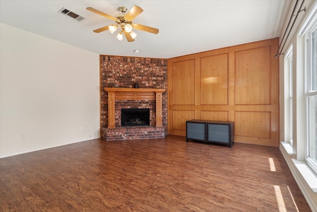 1302 Woodmont Dr, Allen, TX 75002 - unfurnished living room featuring wood finished floors, ceiling fan, a brick fireplace, and baseboards