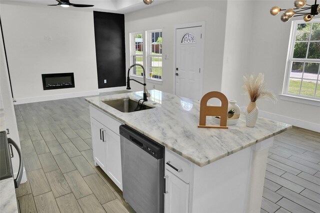 5506 Cold Water Trl, Granbury, TX 76048 - kitchen featuring dishwasher, a sink, an island with sink, wood finish floors, and white cabinets