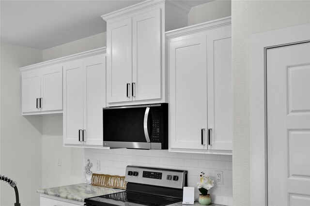5506 Cold Water Trl, Granbury, TX 76048 - kitchen with appliances with stainless steel finishes, tasteful backsplash, and white cabinetry