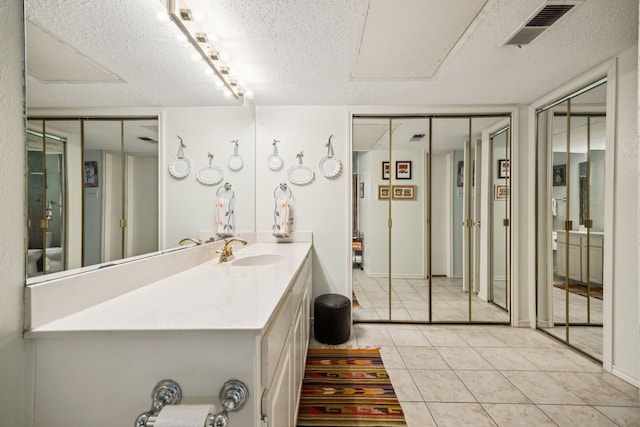 9222 Church Rd Unit 108, Dallas, TX 75231 - bathroom with a textured ceiling, tile patterned floors, and vanity
