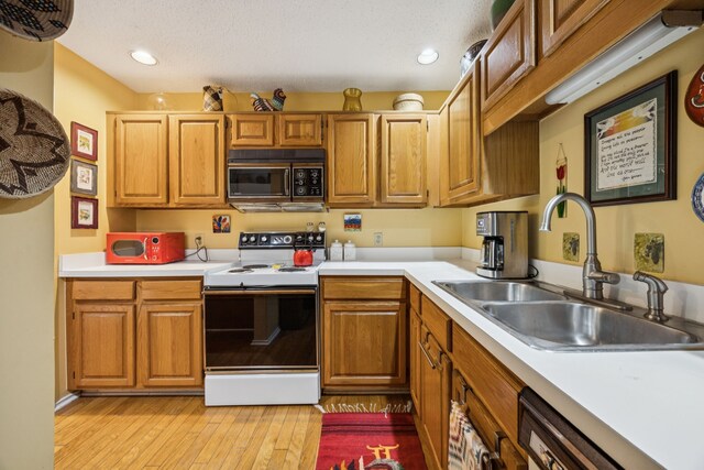 9222 Church Rd Unit 108, Dallas, TX 75231 - kitchen featuring black microwave, electric range, a sink, light countertops, and light wood-style flooring
