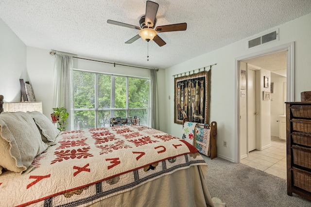 9222 Church Rd Unit 108, Dallas, TX 75231 - bedroom with carpet flooring, a textured ceiling, a ceiling fan, and tile patterned flooring