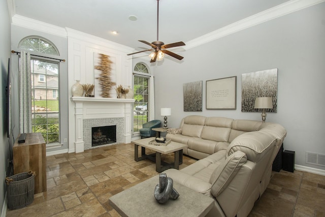 611 Christan Ct, Rockwall, TX 75087 - living room with stone tile flooring, ornamental molding, a ceiling fan, a fireplace, and plenty of natural light