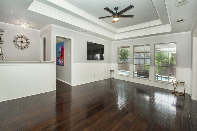 611 Christan Ct, Rockwall, TX 75087 - unfurnished living room with a ceiling fan, a wainscoted wall, hardwood / wood-style flooring, a raised ceiling, and ornamental molding