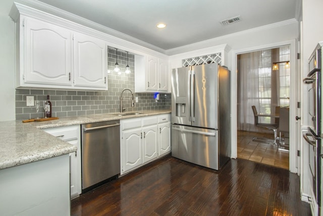 611 Christan Ct, Rockwall, TX 75087 - kitchen featuring stainless steel appliances, a sink, dark wood-style floors, white cabinetry, and crown molding