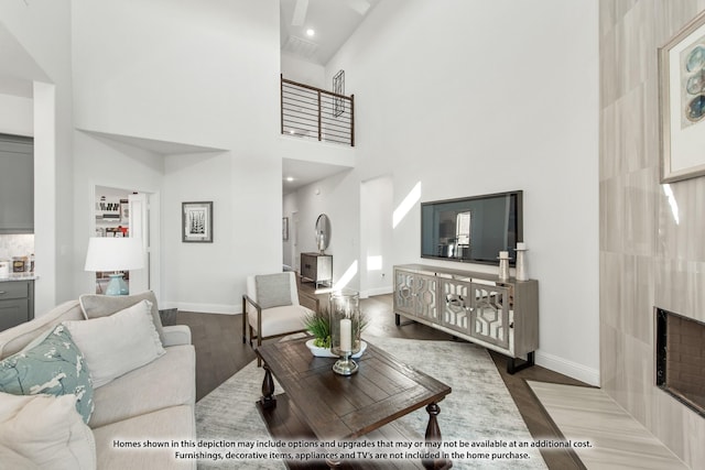 1025 Raptor Rd, Alvarado, TX 76009 - living room featuring wood finished floors, a towering ceiling, baseboards, and a fireplace