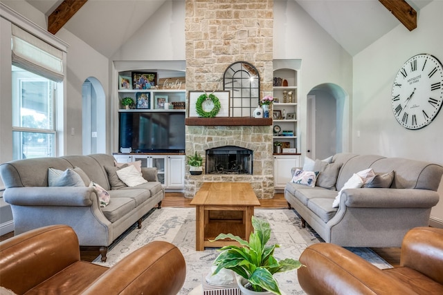 9410 Tay Ln, Justin, TX 76247 - living area featuring high vaulted ceiling, arched walkways, light wood-style flooring, built in features, and beam ceiling
