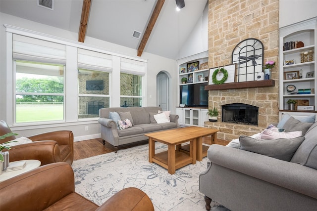 9410 Tay Ln, Justin, TX 76247 - living room featuring wood finished floors, arched walkways, high vaulted ceiling, a fireplace, and beam ceiling