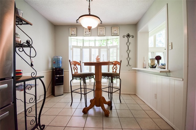 738 Westwood Dr, Marlin, TX 76661 - dining room with a textured ceiling, wainscoting, and light tile patterned floors