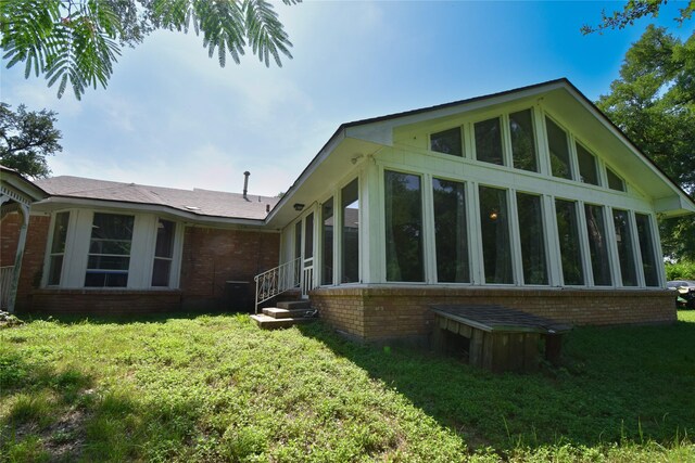 738 Westwood Dr, Marlin, TX 76661 - view of property exterior with brick siding, a sunroom, and a yard
