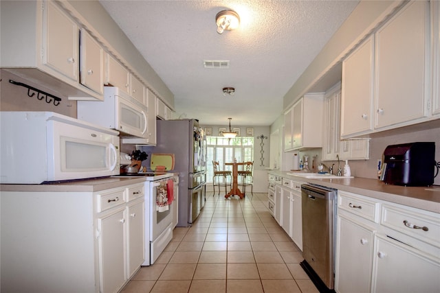 738 Westwood Dr, Marlin, TX 76661 - kitchen featuring white appliances, white cabinetry, light tile patterned flooring, light countertops, and a sink