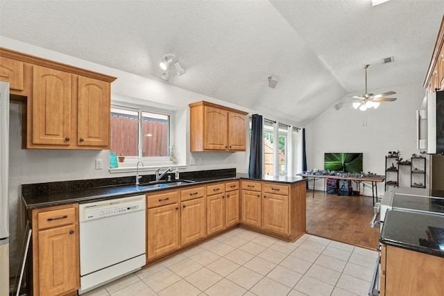 2229 Brooklake St W, Denton, TX 76207 - kitchen with white dishwasher, a sink, a peninsula, light tile patterned floors, and ceiling fan