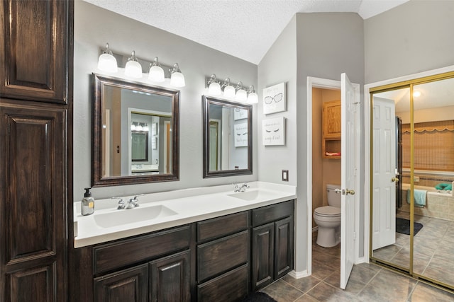 2229 Brooklake St W, Denton, TX 76207 - full bathroom with vaulted ceiling, toilet, double vanity, tile patterned floors, and a textured ceiling