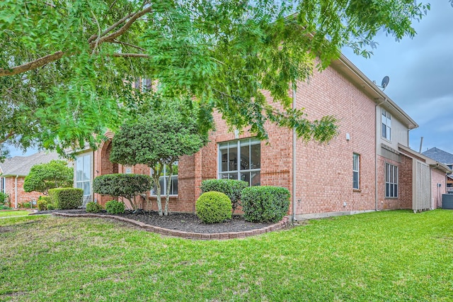 3905 Lakeside Dr, Rowlett, TX 75088 - view of side of home with a yard, brick siding, and central AC unit
