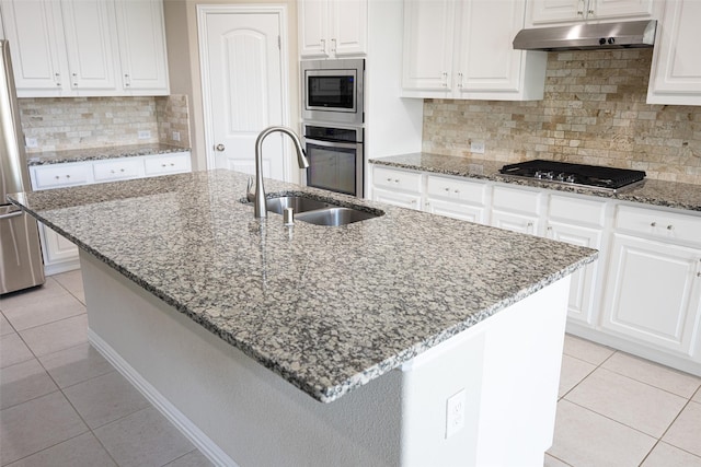 4104 Portola Dr, Mckinney, TX 75070 - kitchen featuring under cabinet range hood, light tile patterned floors, appliances with stainless steel finishes, white cabinetry, and light stone countertops