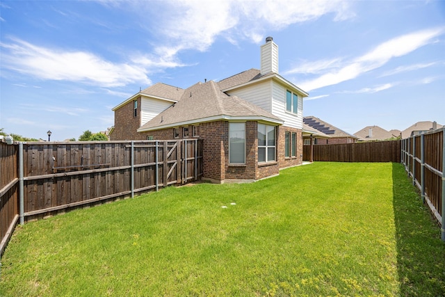 4104 Portola Dr, Mckinney, TX 75070 - rear view of house with brick siding, a chimney, a fenced backyard, and roof with shingles