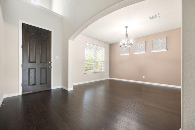 4104 Portola Dr, Mckinney, TX 75070 - entrance foyer with arched walkways, a chandelier, and dark wood finished floors