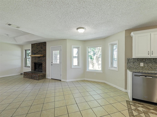 7275 Fm 455 W, Sanger, TX 76266 - unfurnished living room with a fireplace, a textured ceiling, baseboards, and light tile patterned flooring