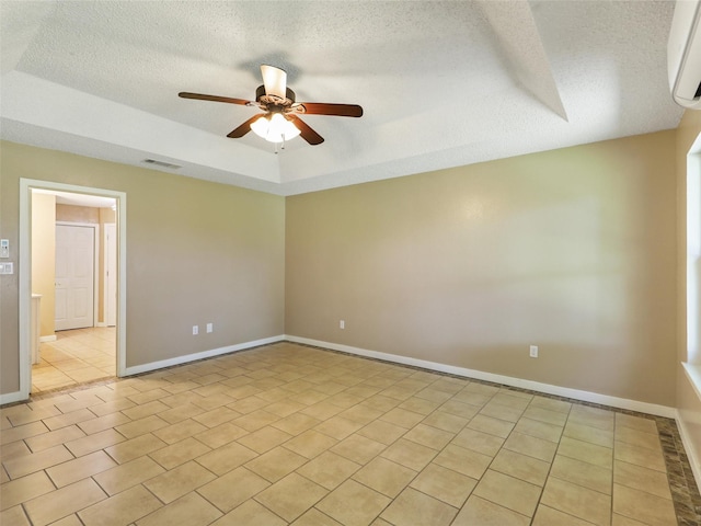 7275 Fm 455 W, Sanger, TX 76266 - spare room featuring a textured ceiling, a ceiling fan, a tray ceiling, a wall mounted AC, and light tile patterned floors