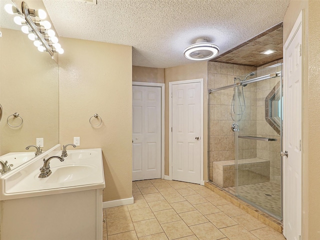 7275 Fm 455 W, Sanger, TX 76266 - bathroom featuring a shower stall, tile patterned flooring, double vanity, a textured ceiling, and baseboards