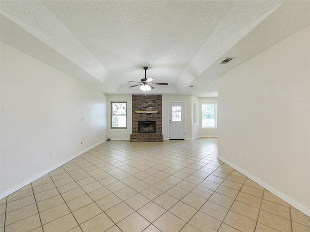 7275 Fm 455 W, Sanger, TX 76266 - unfurnished living room featuring ceiling fan, a textured ceiling, a fireplace, light tile patterned floors, and baseboards