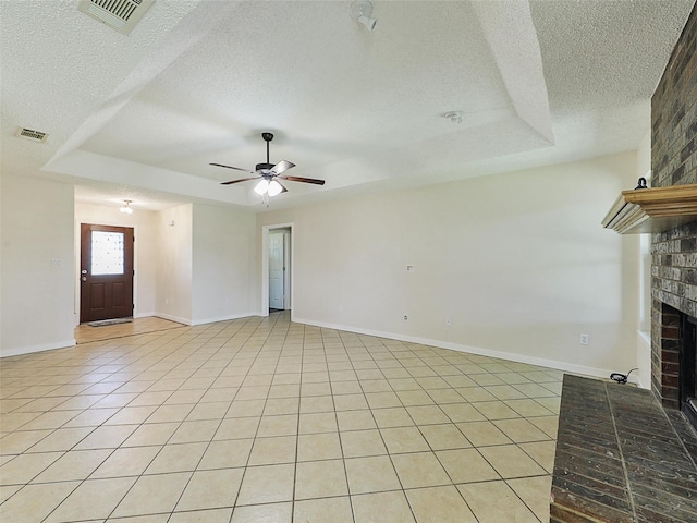 7275 Fm 455 W, Sanger, TX 76266 - unfurnished living room with a textured ceiling, a brick fireplace, a tray ceiling, ceiling fan, and light tile patterned floors