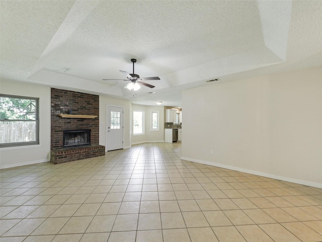 7275 Fm 455 W, Sanger, TX 76266 - unfurnished living room with a tray ceiling, plenty of natural light, a textured ceiling, a ceiling fan, and baseboards