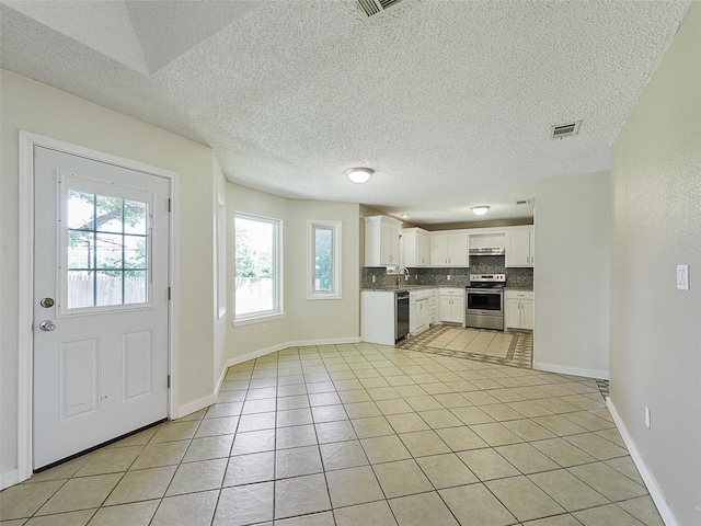 7275 Fm 455 W, Sanger, TX 76266 - kitchen featuring stainless steel range, dishwasher, under cabinet range hood, decorative backsplash, and light tile patterned floors