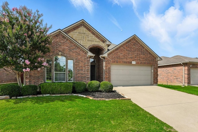 3112 Stonecrop Trl, Denton, TX 76226 - view of front of home featuring an attached garage, driveway, a front yard, and brick siding