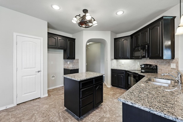 3112 Stonecrop Trl, Denton, TX 76226 - kitchen with black appliances, arched walkways, light stone counters, a kitchen island, and decorative backsplash
