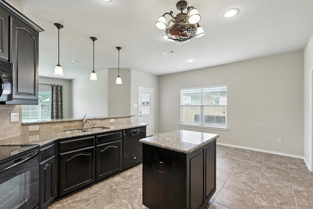 3112 Stonecrop Trl, Denton, TX 76226 - kitchen with black appliances, tasteful backsplash, a peninsula, light stone countertops, and recessed lighting