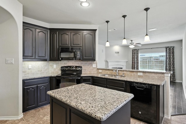 3112 Stonecrop Trl, Denton, TX 76226 - kitchen with black appliances, a peninsula, decorative backsplash, and light stone countertops